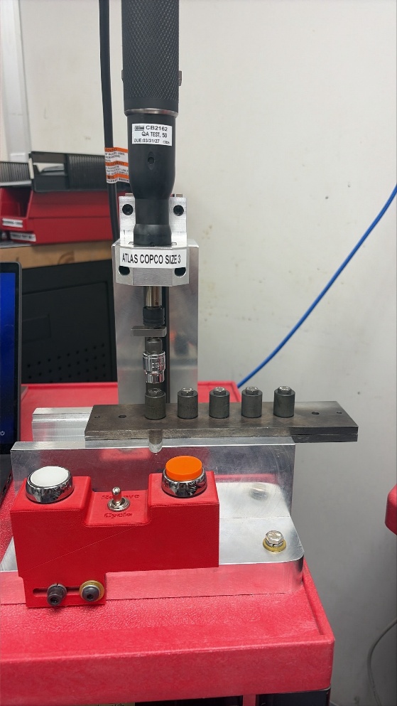 Existing Atlas Copco Torque Control Unit mounted above a five-bolt test fixture