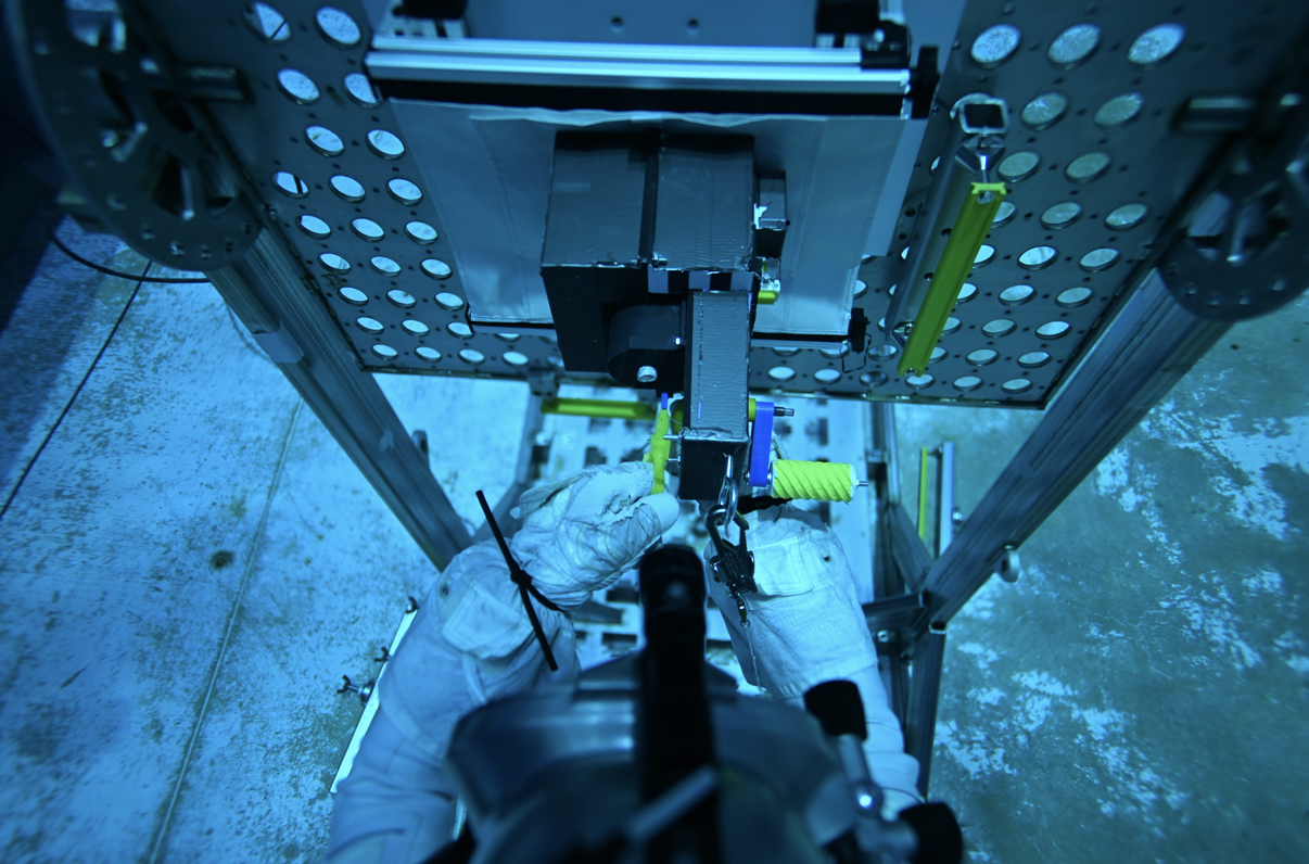 Astronaut holding the Cerritos College team sign during an EVA tool test