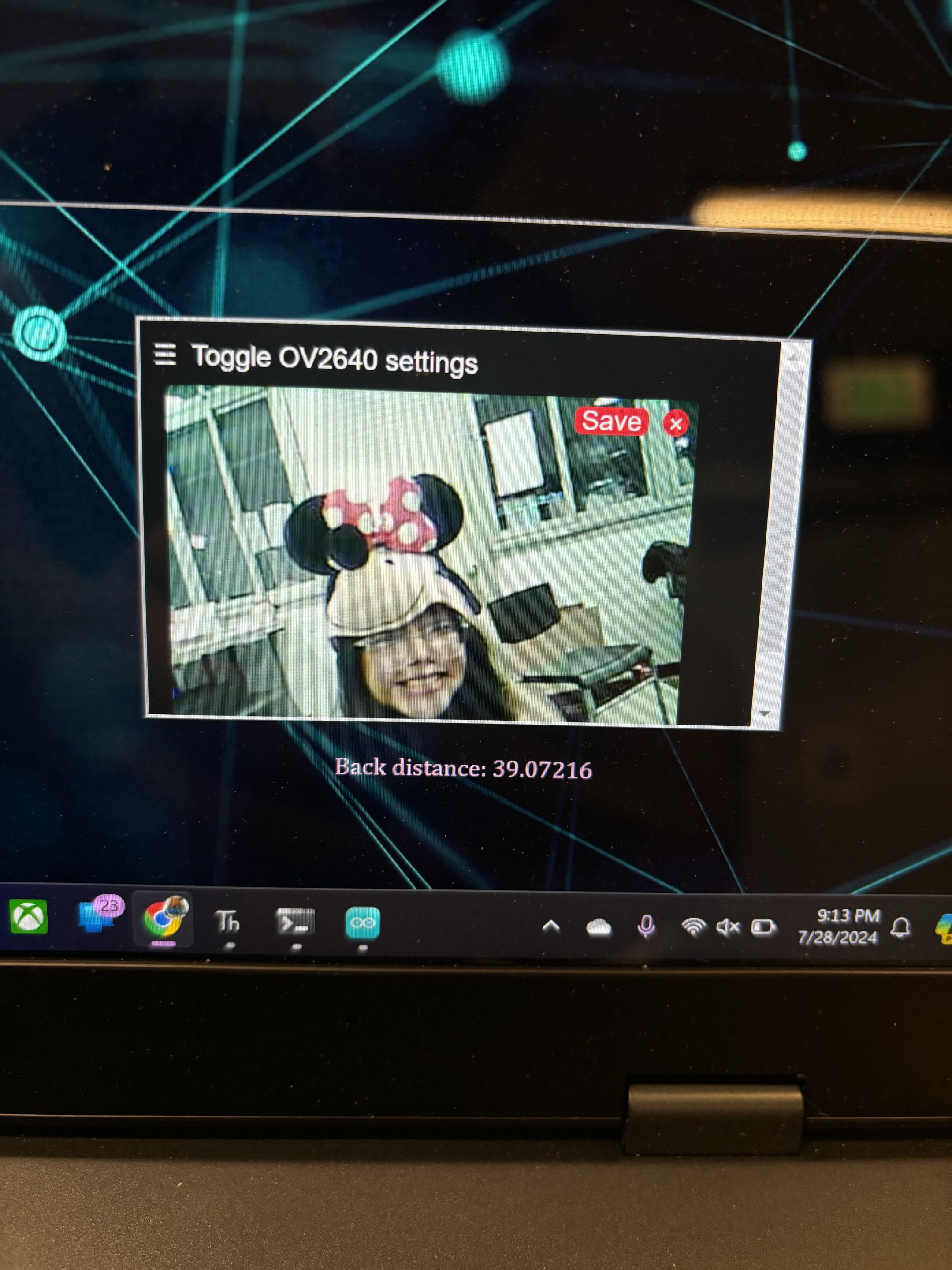 Laptop displaying the rover's camera feed and rear-distance readout