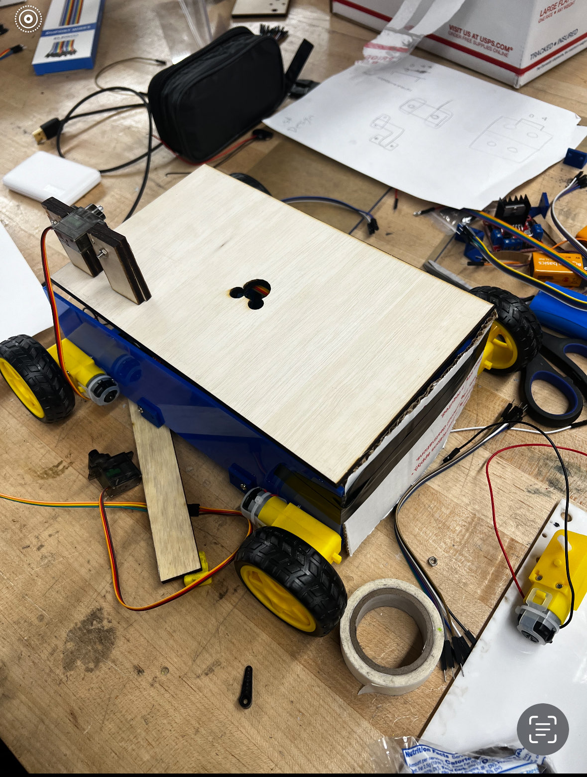 Rover chassis with a wooden top deck, wheels, motors, and mounting hardware during assembly
